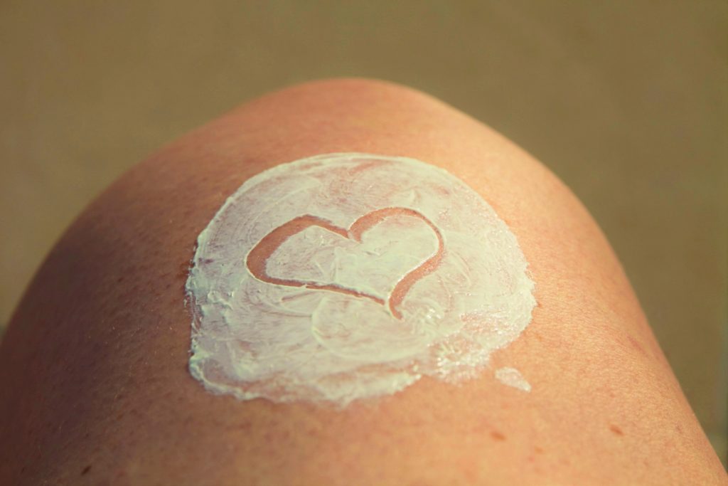Sunscreen lotion on leg with a heart drawn